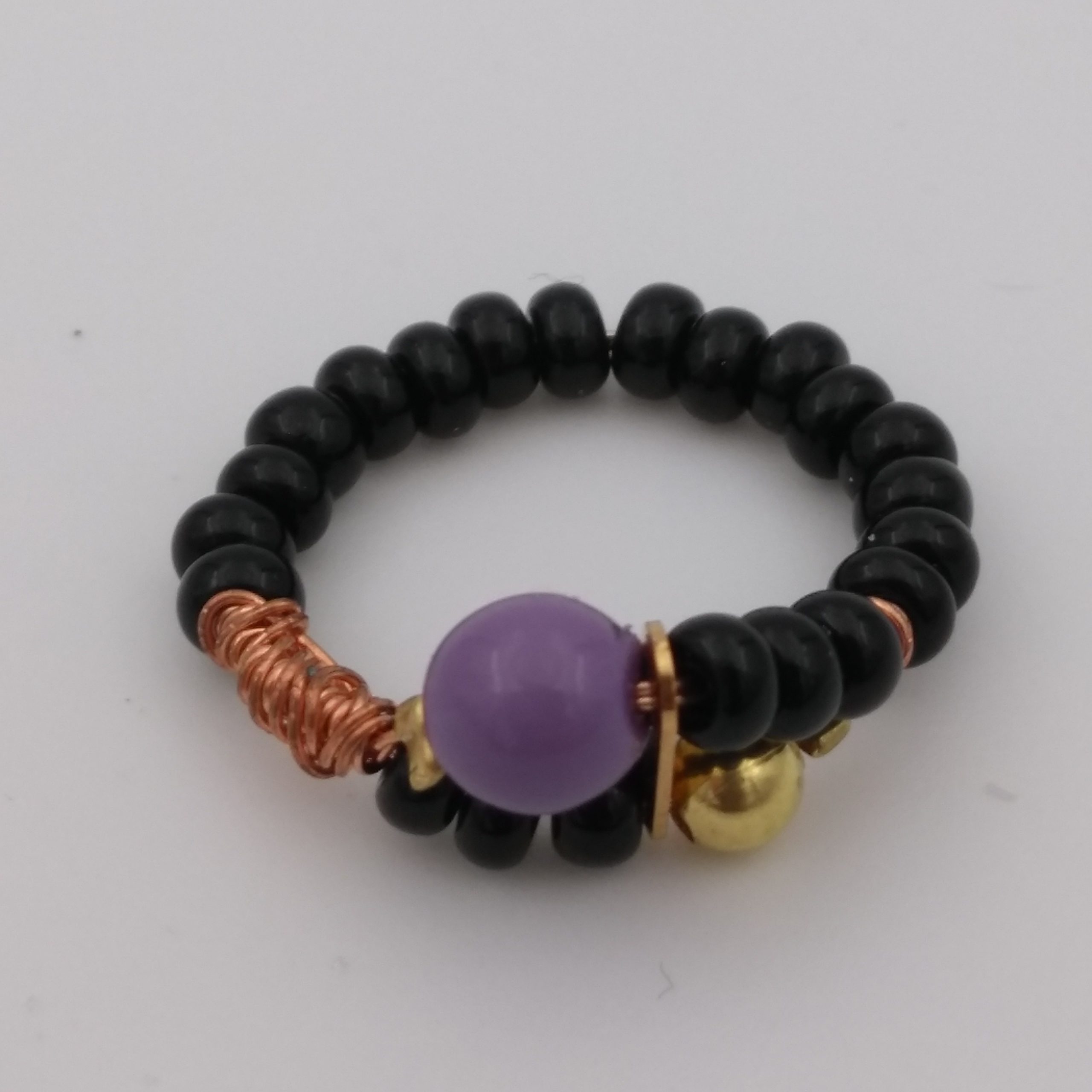 Bague avec perles noires, violettes et dorées